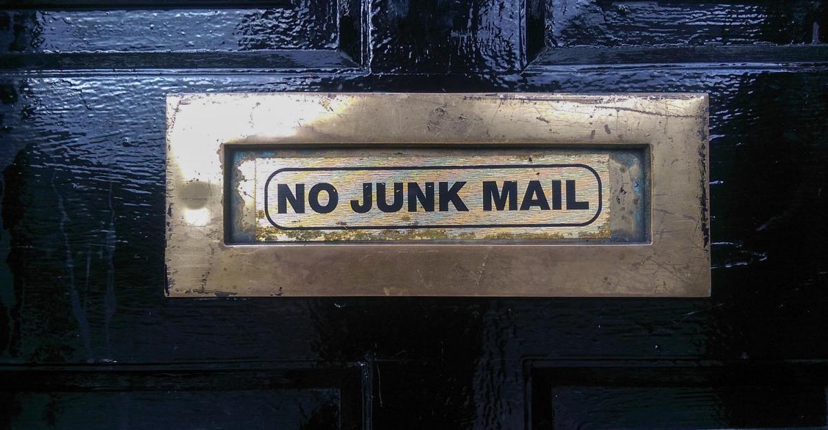 No Junk Mail written on the mailbox window of this door.